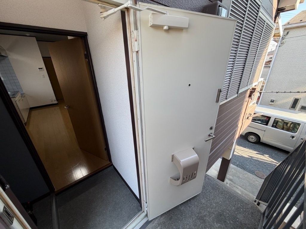 埼玉県幸手市の賃貸アパート共用廊下側玄関ドア シート施工後 美観が回復した状態