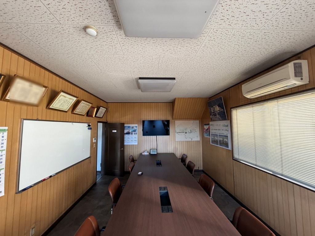 茨城県古河市の会社事務所におけるクロス張替え後の会議室 グレー系壁紙でモダンな印象に改善した状態