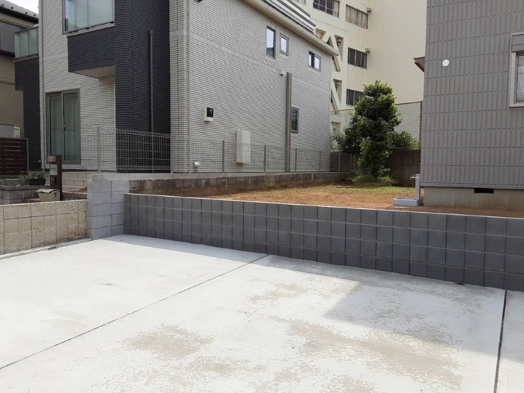 春日部市 外構工事後 土留めブロックと駐車場土間コンクリートで敷地まわりを整えた様子